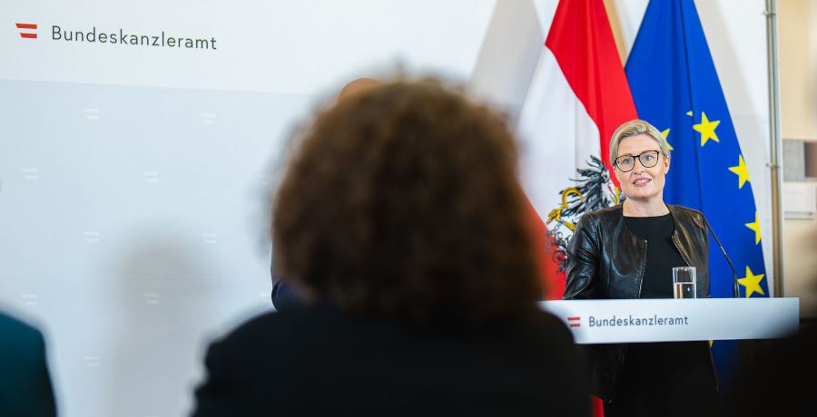 Bundesministerin Susanne Raab steht am Rednerpult bei einer Pressekonferenz